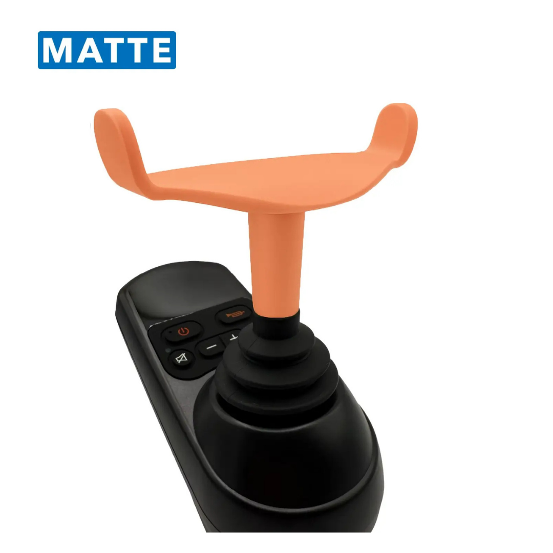 A close-up of the ComfyGo Ergonomic U-Shaped Joystick Handle with Flex Shaft for Powerchairs, featuring a black handle, orange U-shaped top attachment, and multiple black buttons, shown against a white background. The word MATTE is in a blue box at the top left.